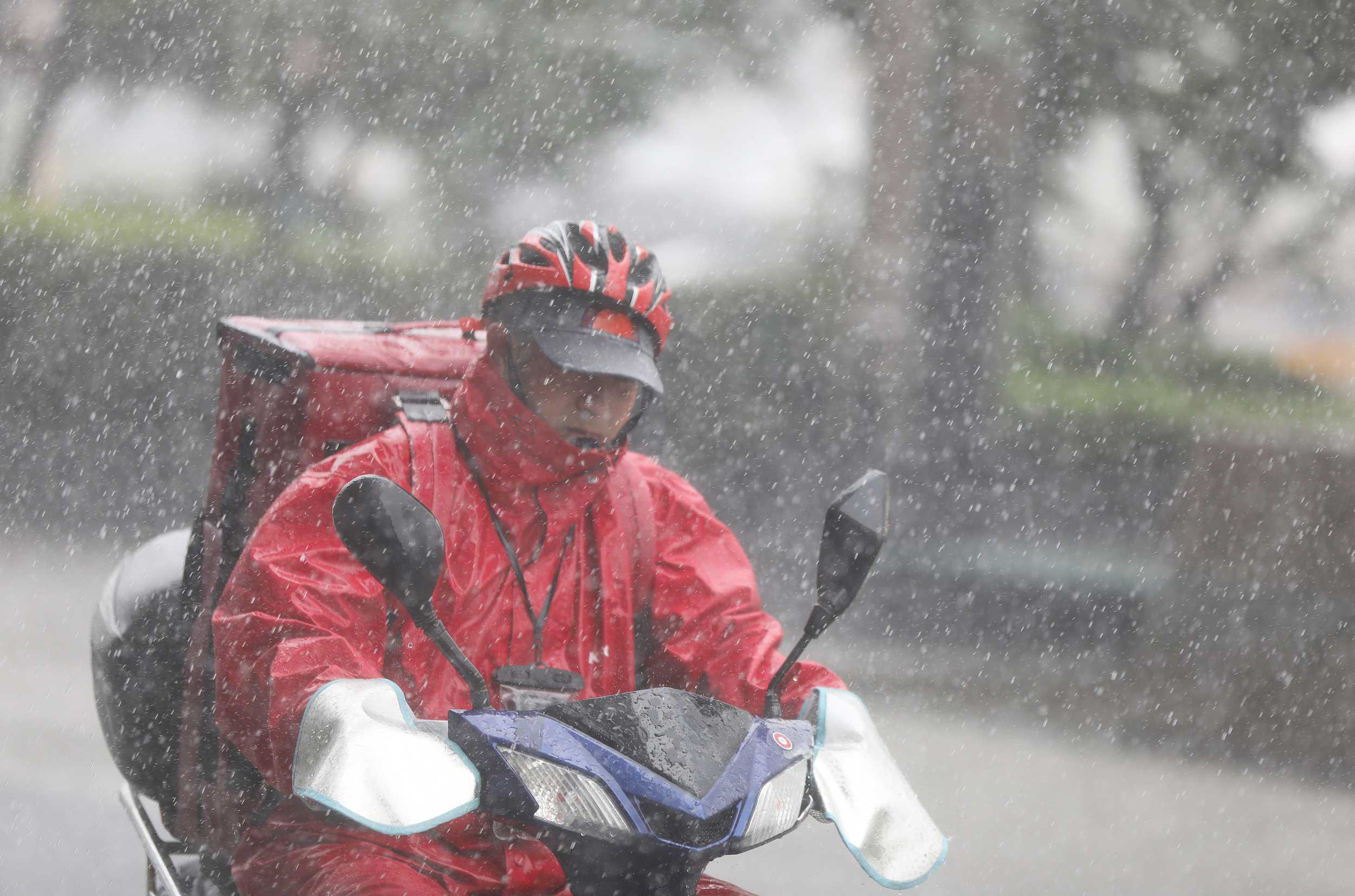 2021年7月14日,青岛迎来暴雨天气,市民冒雨出行,外卖员依旧坚守在岗位