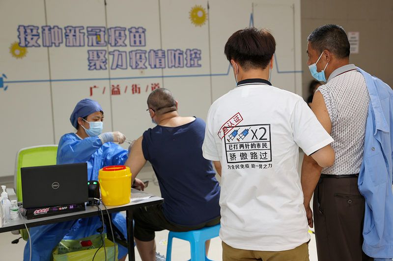 2021年8月11日,江苏无锡,身着"已打疫苗"文化衫的志愿者在疫苗接种点