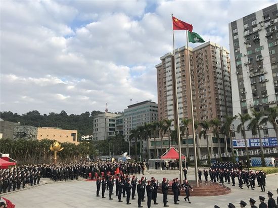 全场肃立高唱国歌,五星红旗和澳门特区区旗在众人的注视中,冉冉升起