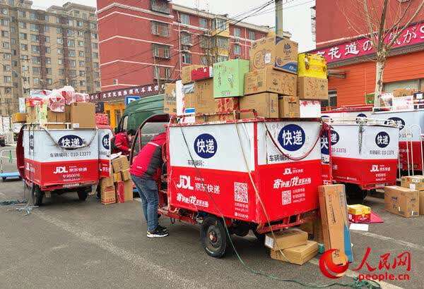 北京市朝阳区一家京东物流配送站外,快递员正在分拣货品
