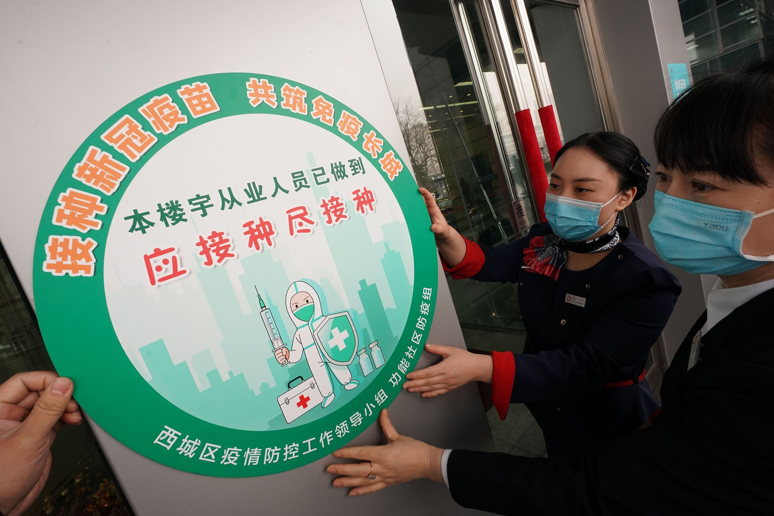 这张绿色的标识证明该楼宇疫苗接种人数超