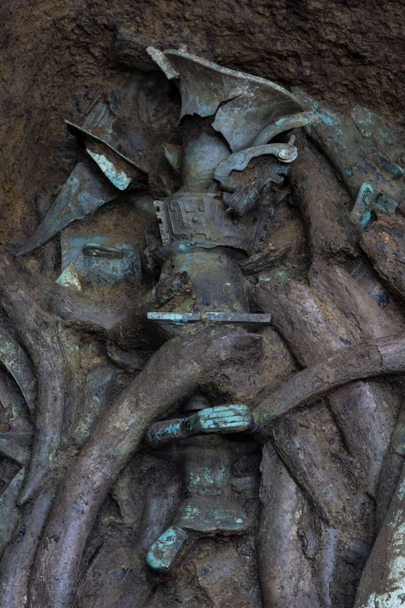 在三星堆遗址考古发掘现场,考古人员在5号"祭祀坑"内清理文物(3月19日