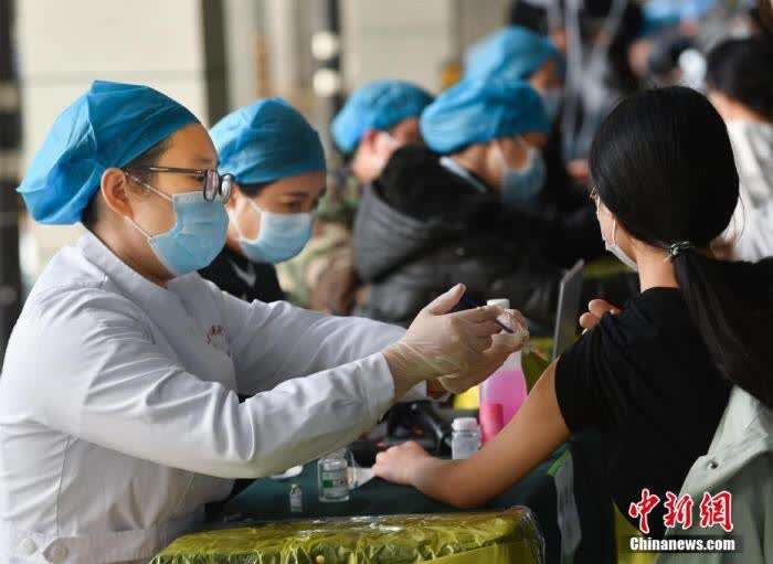 3月25日,在武汉大学卓尔体育馆,学生有序排队,接种新冠疫苗李晗 摄
