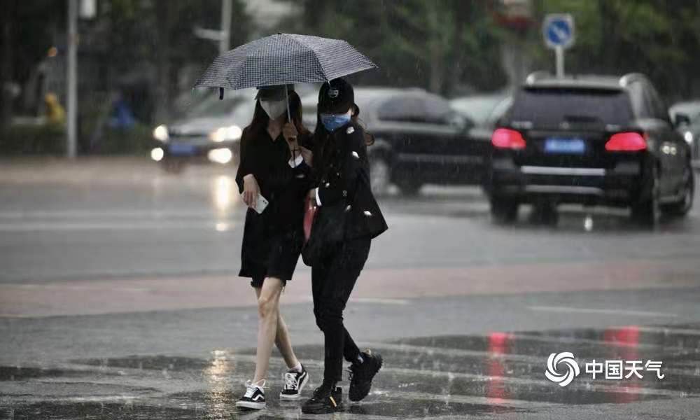 北京雷声滚滚迎来降雨 早高峰行人冒雨出行