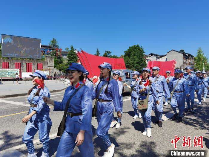 图为游客穿着红军衣服在猴场会议会址行走。 周燕玲 摄