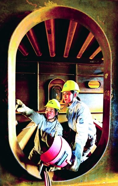 王中美(右)在现场指导徒弟刘青,她们都是女子电焊工中的佼佼者.