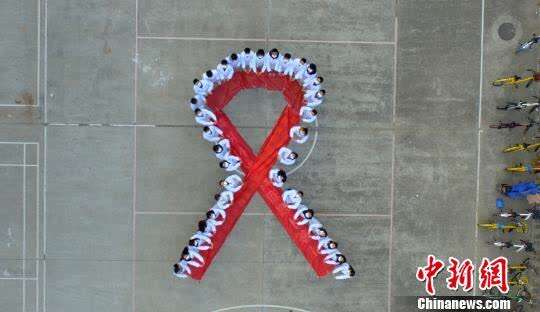 资料图：大学生们携手“抗艾”，拼大型“红丝带”图案。　孟德龙 摄