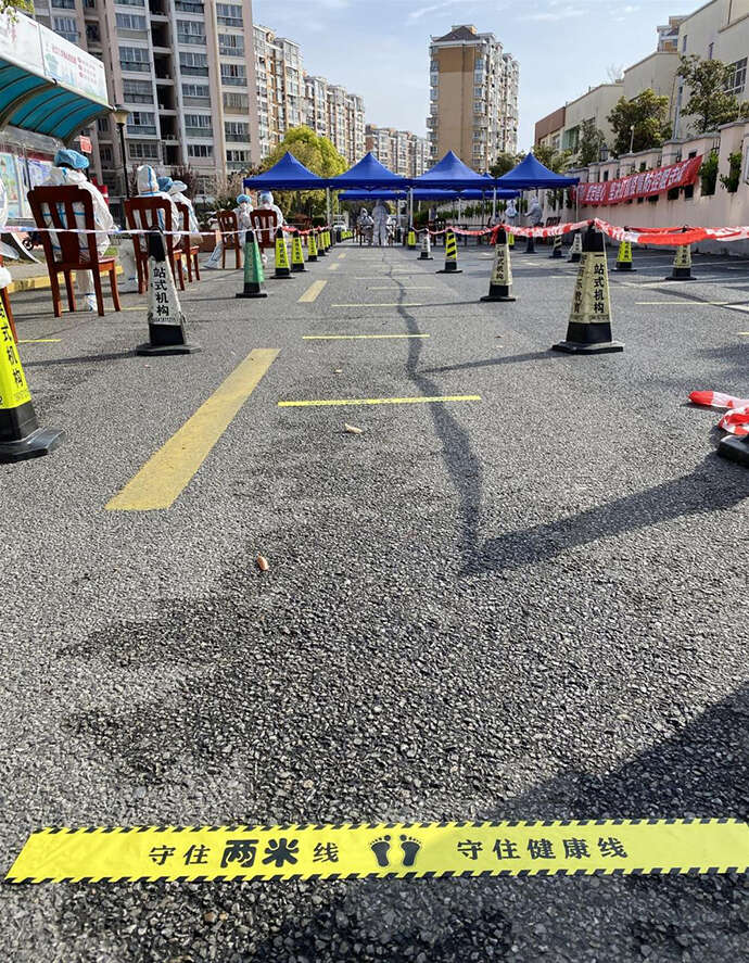 地面黄线上“守好2米线,守好健康线”的醒目标语。