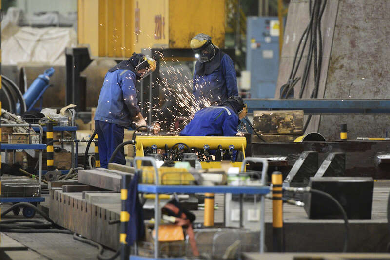 2022年4月23日，上海电气，工人在焊接机器部件。