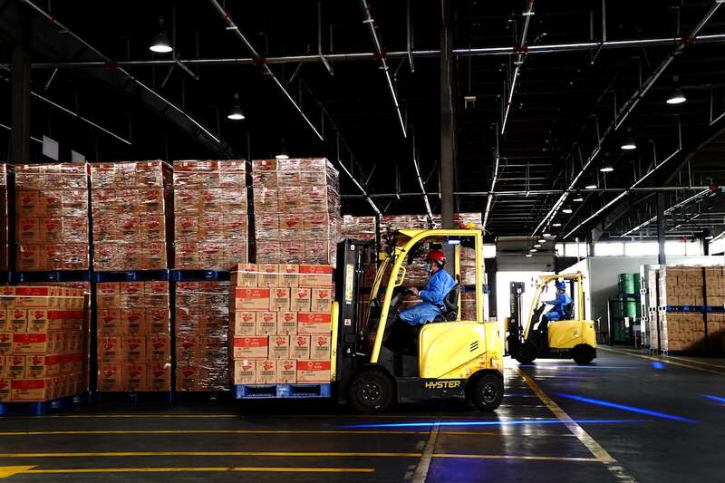 2022年4月22日，在上海嘉里食品工业有限公司的仓库，叉车操作人员运输食用油产品。