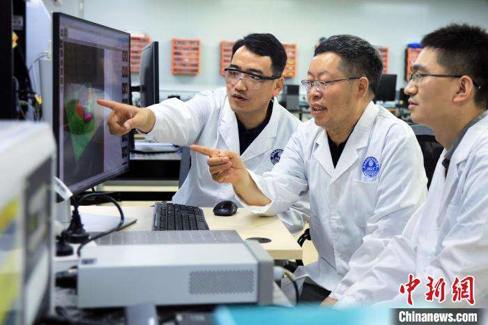 中科院大连化物所李灿院士(中)、范峰滔研究员(左)和陈若天副研究员在仪器前讨论信号分析问题。　中科院大连化物所 供图