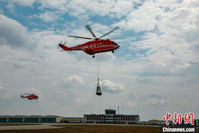 图为直升机用吊网将物资运送至目标地域。　张宇 摄