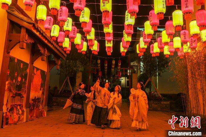 图为几位身着古装的游客在阳明古街内欣赏花灯。　刘力鑫 摄