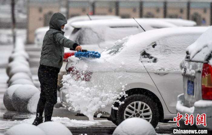 市民清理汽车上的积雪。　刘新 摄