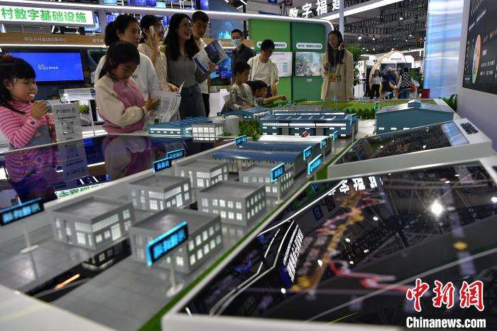 图为家长们带小朋友在展馆内参观现代数字农业模型。　张斌 摄