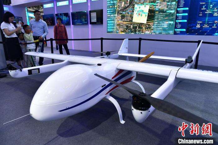 图为民众在参观展示载荷丰富、实时双向通讯、多场景运用且油电混合的固定翼无人机。　张斌 摄