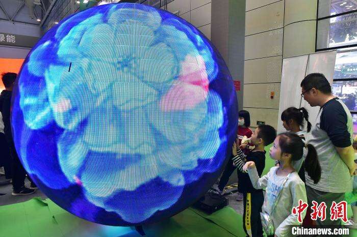 图为展馆内直径达5米，可播放视频、图文及各类信息的内球幕，吸引小朋友们的眼球。　张斌 摄