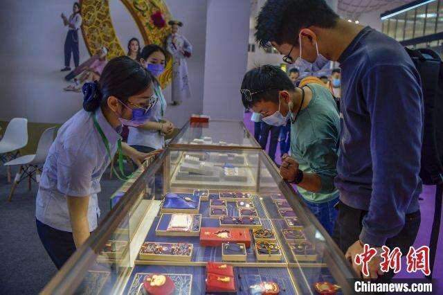 资料图：民众在2022世界珠宝发展大会的菜百展台上选购古法金饰品。 骆云飞摄